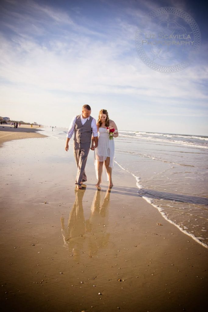 Newlyweds Walking Along Beach