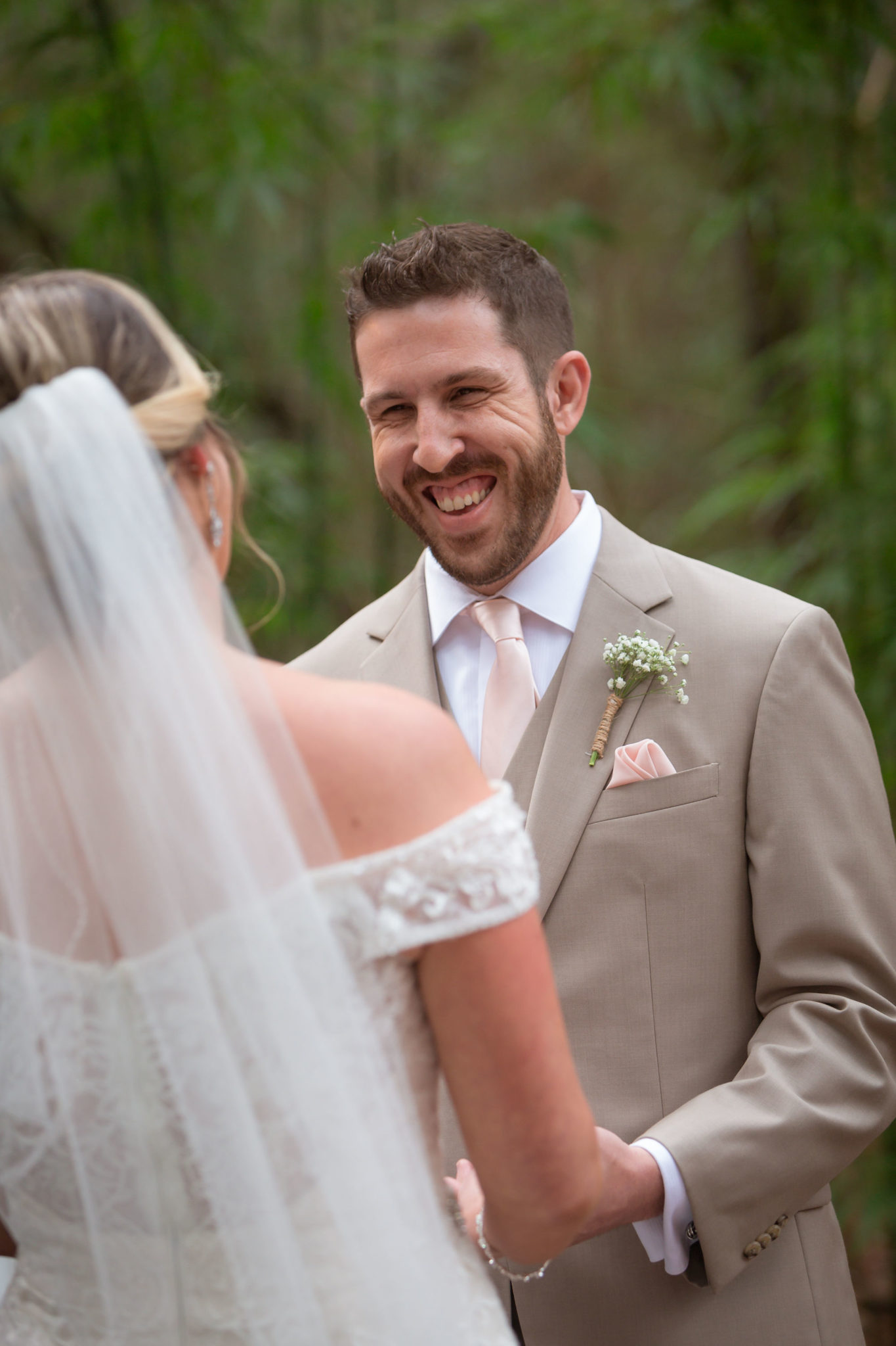 The groom smiling at his bride during the ceremony.