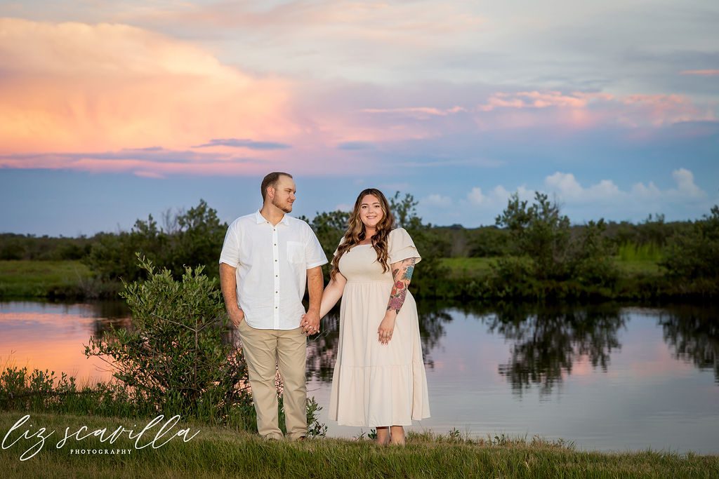 Amber and Nathan beside the marsh at sunset on the Ormond Scenic Loop