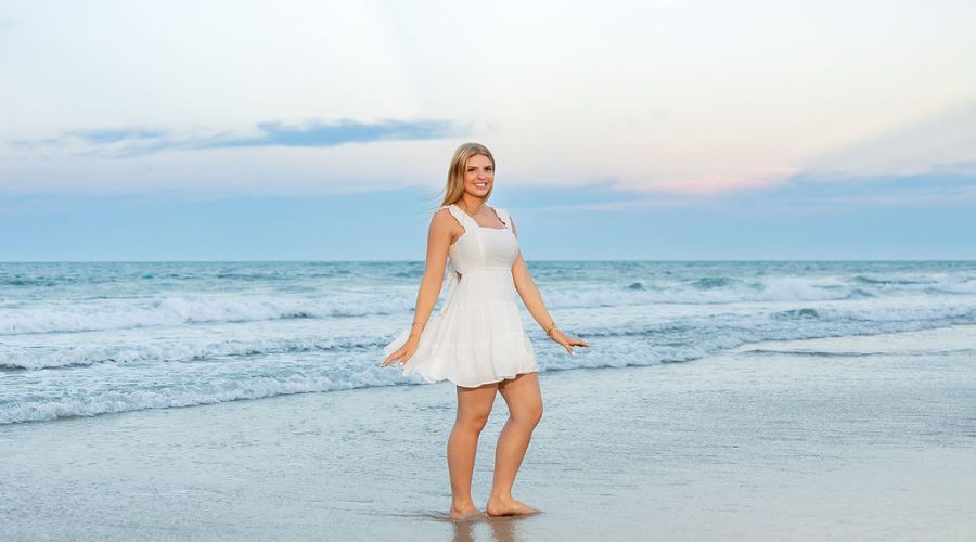Ormond Beach senior photos of Ryann reflected in wet sand beneath a pastel sky