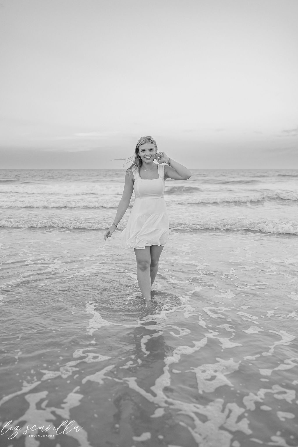 Black-and-white portrait of Ryann with one hand near her hair in the surf